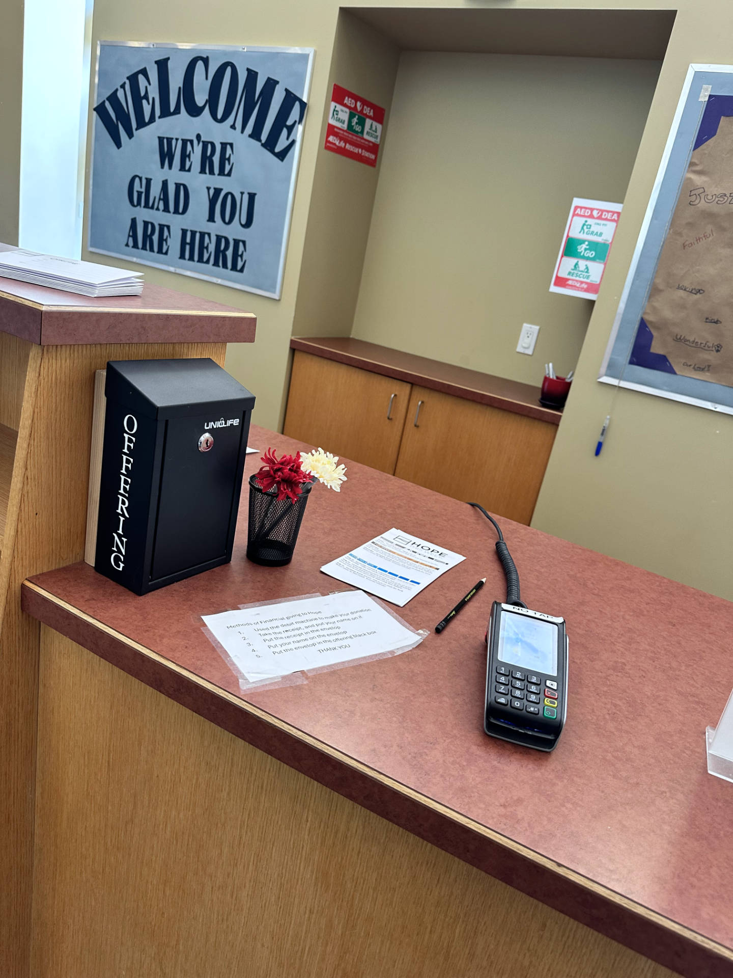 Offering box and debit machine at the Welcome Desk